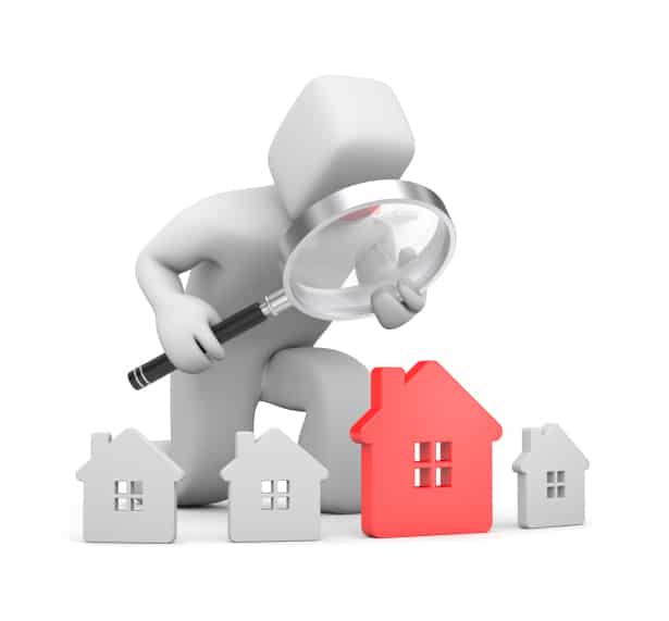 man with magnifying glass looking at modal houses In the search for a new house